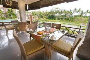 a dining room with a table and chairs and a view at Om Ham Retreat and Resort in Ubud