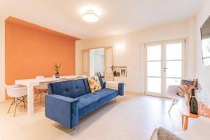 een woonkamer met een blauwe bank en een tafel bij Luxury & Design: Oasi nel centro storico di Rimini in Rimini