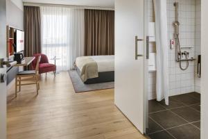 a hotel room with a bed and a desk at IntercityHotel Heidelberg in Heidelberg