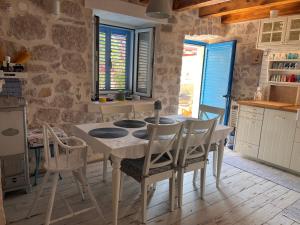 a kitchen with a table and chairs in a room at Villa Tomitorija in Kaprije