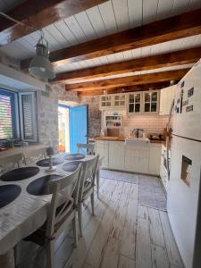 a kitchen with a table and chairs and a refrigerator at Villa Tomitorija in Kaprije