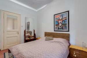 a bedroom with a bed and a painting on the wall at City Apartment With Garden - Happy Rentals in Rijeka