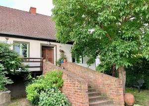 a person walking up a brick wall in front of a house at Oak House Nowy Dworek in Świebodzin