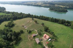 an aerial view of a house on a field next to a lake at Zacisze nad Rospudą in Filipów