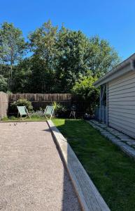 a yard with two lawn chairs and a house at Maison chaleureuse - Gérardmer in Gérardmer