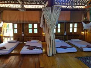 um quarto com quatro camas com cortinas em Vu Linh Palm House Homestay - Bungalow em Yen Bai