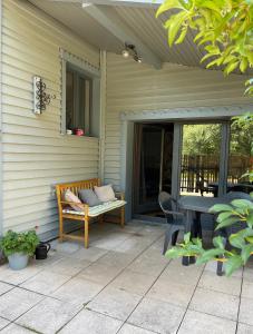 un patio con un banco y una mesa en una casa en Maison chaleureuse - Gérardmer, en Gérardmer