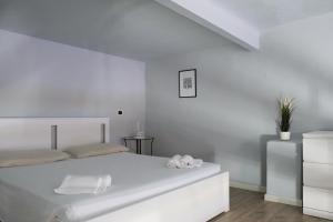 ein weißes Schlafzimmer mit einem weißen Bett und 2 Handtüchern in der Unterkunft Carega City Center Apartment in Verona