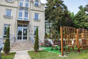 un bâtiment avec une table et des chaises devant lui dans l'établissement Hotel Duchess, à Varna