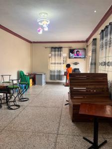 a woman standing in a living room with a tv at DB COMFORT MOTEL in Nkampa