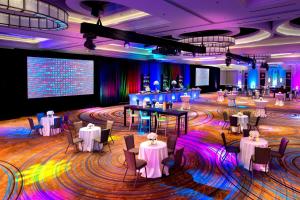 a ballroom with tables and chairs and a stage at Newark Liberty International Airport Marriott in Newark