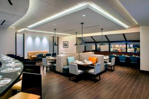 uma sala de jantar com mesas e cadeiras e um restaurante em Newark Liberty International Airport Marriott em Newark