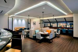 una sala da pranzo con tavoli e sedie e un ristorante di Newark Liberty International Airport Marriott a Newark