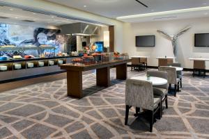 a lobby with a table and chairs and a buffet at Newark Liberty International Airport Marriott in Newark