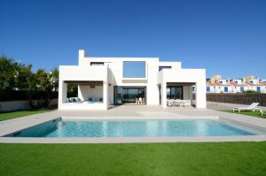 eine Villa mit einem Swimmingpool vor einem Haus in der Unterkunft VILLA PINELL in Torroella de Montgrí