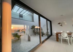 ein Wohnzimmer mit einem großen Fenster und einem Esstisch in der Unterkunft VILLA PINELL in Torroella de Montgrí