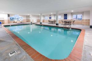 a large swimming pool with blue water in a building at Microtel Inn & Suites by Wyndham Oklahoma City Airport in Bethany