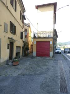 un callejón con un garaje rojo al lado de un edificio en appartamento in Borgo storico., en Pontremoli