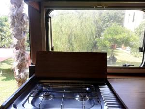 Cordenons的住宿－Il Camper di Ermione，一间带炉灶的厨房 窗边的顶部烤箱