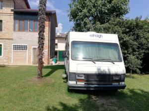 un camión blanco estacionado frente a una casa en Il Camper di Ermione en Cordenons
