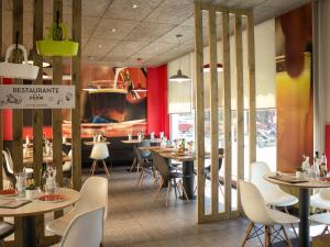 a dining room with tables and chairs in a restaurant at Ibis Sevilla in Seville