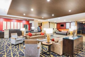 a hotel lobby with couches and tables and chairs at Ramada by Wyndham Grand Forks in Grand Forks
