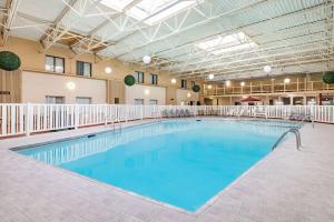 ein großer Pool mit blauem Wasser in einem Gebäude in der Unterkunft Ramada by Wyndham Grand Forks in Grand Forks