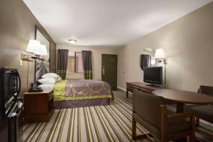 チルドレスにあるSuper 8 by Wyndham Childressのベッド1台、薄型テレビが備わるホテルルームです。