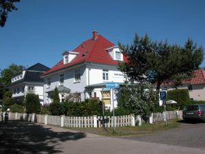 ein großes weißes Haus mit rotem Dach in der Unterkunft Haus Sonneneck 2 in Dierhagen