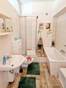 ein Badezimmer mit einem Waschbecken, einer Badewanne und einem WC in der Unterkunft 2-Zimmer-Apartment für 4 PersonenFeWo 1 