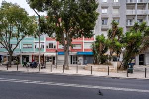 une rue de la ville avec des arbres et un bâtiment dans l'établissement Akicity Benfica Serene, à Lisbonne