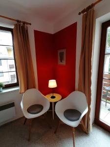 a room with two chairs and a table with a lamp at Apartmán Na Horách in Deštné v Orlických horách