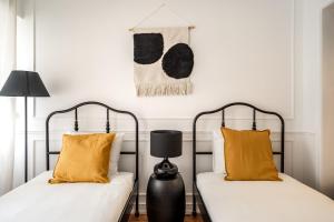- 2 lits avec des oreillers orange dans une chambre dans l'établissement Akicity Benfica Serene, à Lisbonne