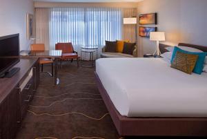 a hotel room with a large bed and a living room at Grand Hyatt Denver in Denver