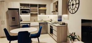 uma cozinha com uma mesa e cadeiras azuis num quarto em 2 bedrooms apartment em Joanesburgo