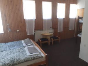 a bedroom with a bed and a table and windows at BOUDA MORAVA in Dolni Dvur