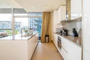 a kitchen with white cabinets and a large window at Fully Furnished 3BR+ Maid’s in the heart of Dubai in Dubai