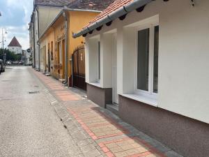 an empty street next to a building with windows at Pap köz apartman in Sárvár