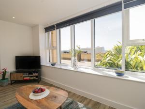 a living room with a table and a large window at The Studio in Weston-super-Mare