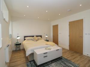 a white bedroom with a bed and a table at The Studio in Weston-super-Mare