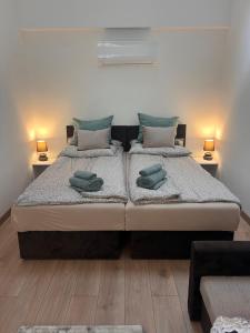 a bedroom with two beds and two lamps on the floor at Pap köz apartman in Sárvár
