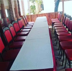 a long table in a room with red chairs at Platinum Hotels Mombasa in Shanzu