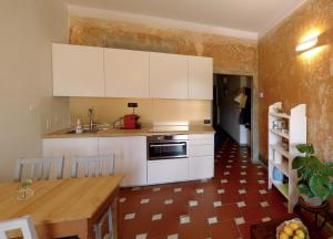 フィレンツェにあるApartment San Fredianoの白いキャビネットと木製テーブル付きのキッチン