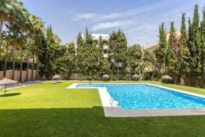 a swimming pool in the middle of a yard with trees at OleHolidays 624 Duplex Carib Playa 200 mts. playa in Marbella