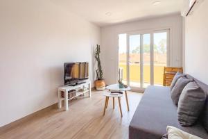 a living room with a couch and a tv at OleHolidays 624 Duplex Carib Playa 200 mts. playa in Marbella