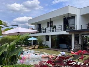 una villa con piscina e una casa di Mestiza Hospedaje familiar a Quimbaya