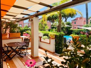 un patio al aire libre con mesa, sillas y plantas en Residence dei Fiori en Campo nell'Elba
