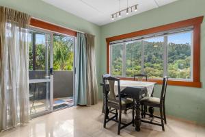 uma sala de jantar com uma mesa e uma grande janela em Hatea Drive Accommodation em Whangarei