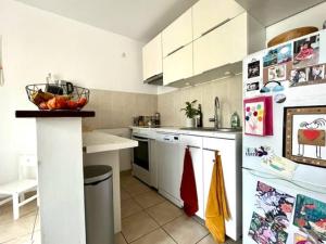 une cuisine avec des placards blancs et un comptoir dans l'établissement Appartement cosy jardin des plantes avec parking, à Nantes