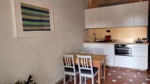 eine Küche mit einem Holztisch und weißen Schränken in der Unterkunft Apartment San Frediano in Florenz